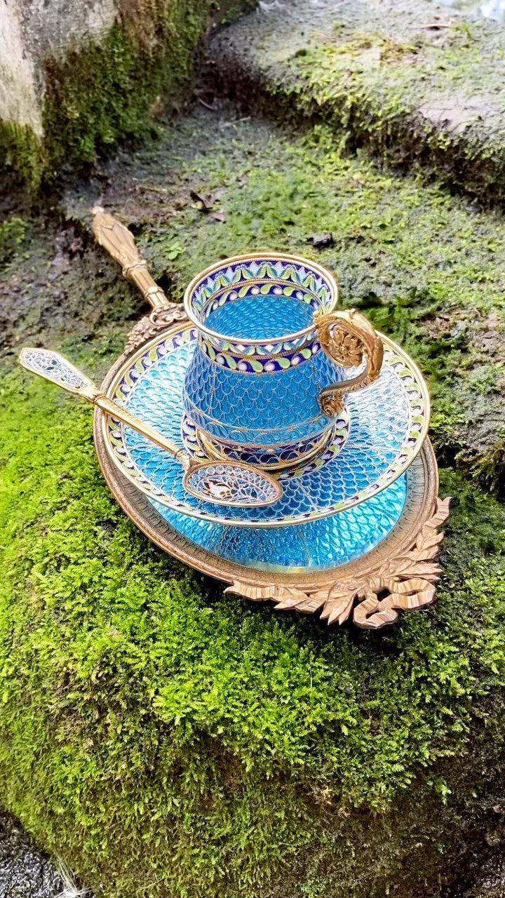 17 Antique Coffee Decor Ideas for Your Kitchen or Nook 10 Ornate blue and gold coffee cup and saucer on a gold tray over moss.