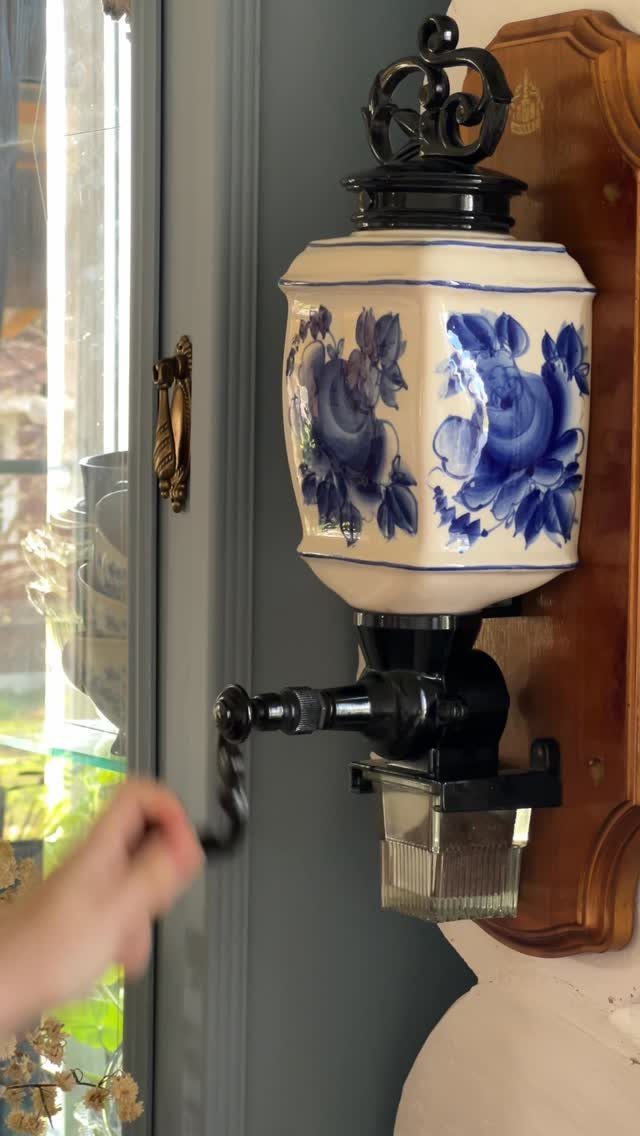 17 Antique Coffee Decor Ideas for Your Kitchen or Nook 13 Antique wall-mounted coffee dispenser with blue floral ceramic reservoir and black metal tap.