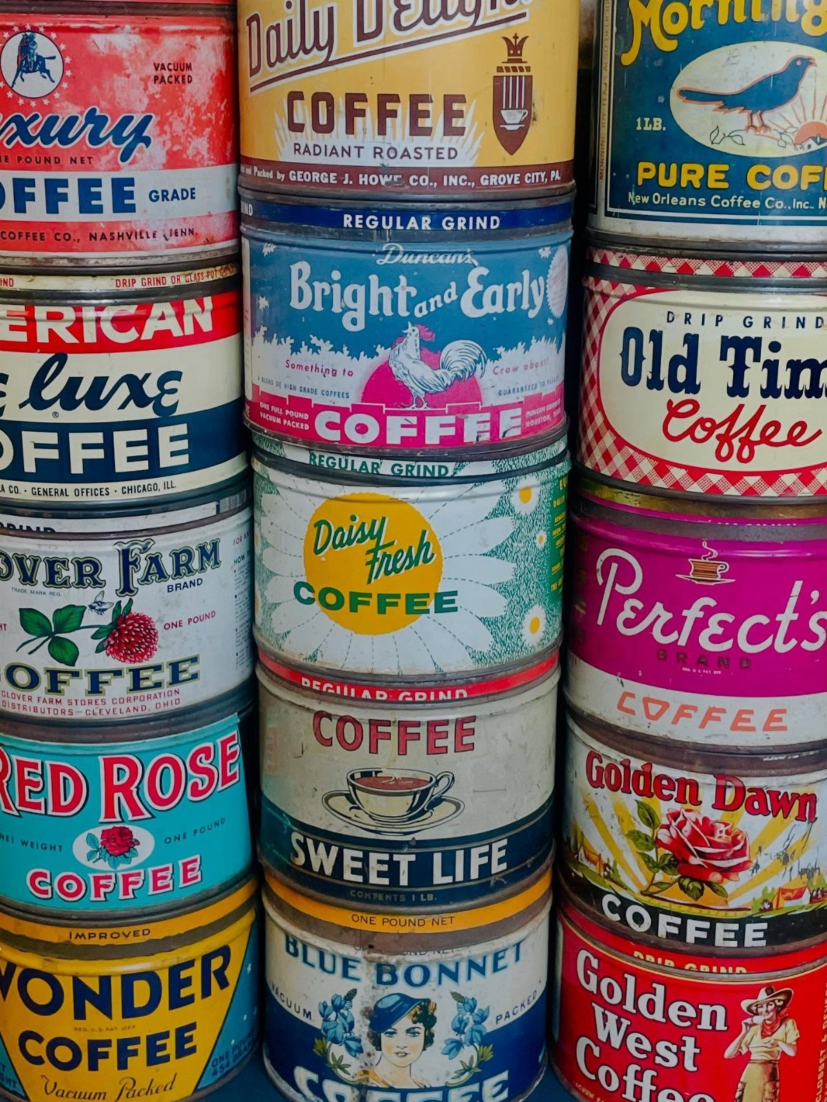 17 Antique Coffee Decor Ideas for Your Kitchen or Nook 7 Stacked vintage metal coffee tins with colorful retro labels and classic brand illustrations.