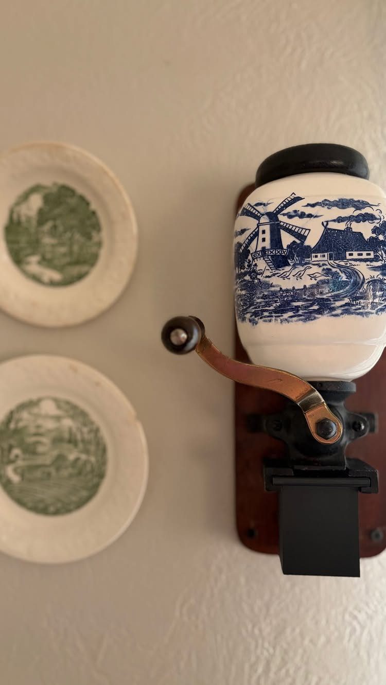 17 Antique Coffee Decor Ideas for Your Kitchen or Nook 15 Vintage wall-mounted coffee grinder with windmill pattern and two small decorative plates.