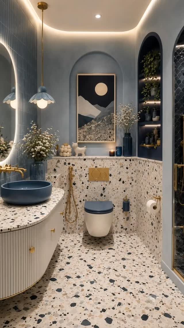 Modern bathroom with white terrazzo floors and walls paired with brass fixtures.