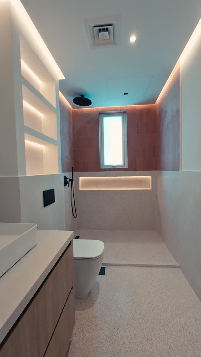 Light terrazzo flooring in a modern bathroom with a white toilet and vanity.