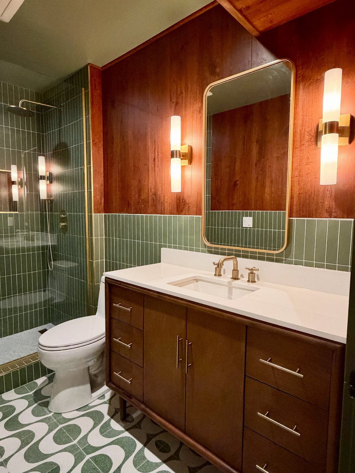 Bathroom with green patterned terrazzo flooring and a dark wood vanity cabinet.