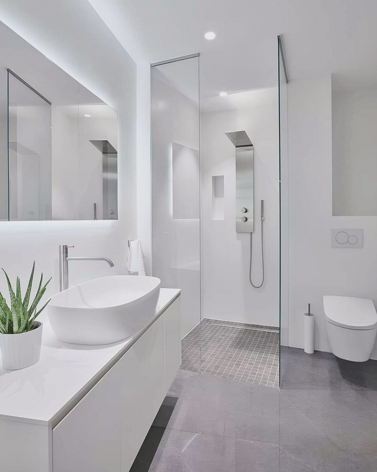 Floating white vanity with a white vessel sink in a modern minimalist bathroom.