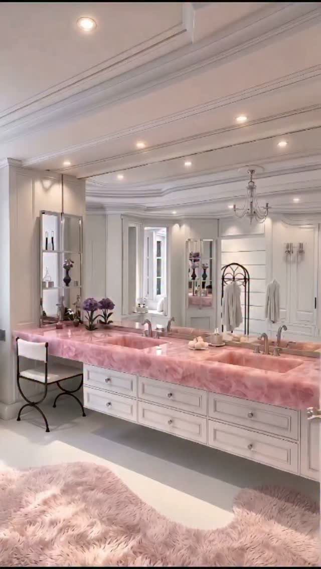 White bathroom vanity with pink marble countertop and sinks in a bright room.