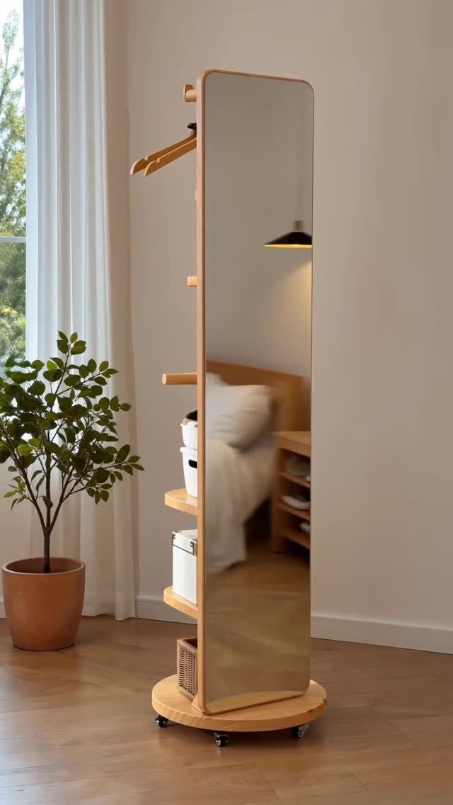 Full-length mirror with light wood frame and integrated storage shelves on a wheeled base.