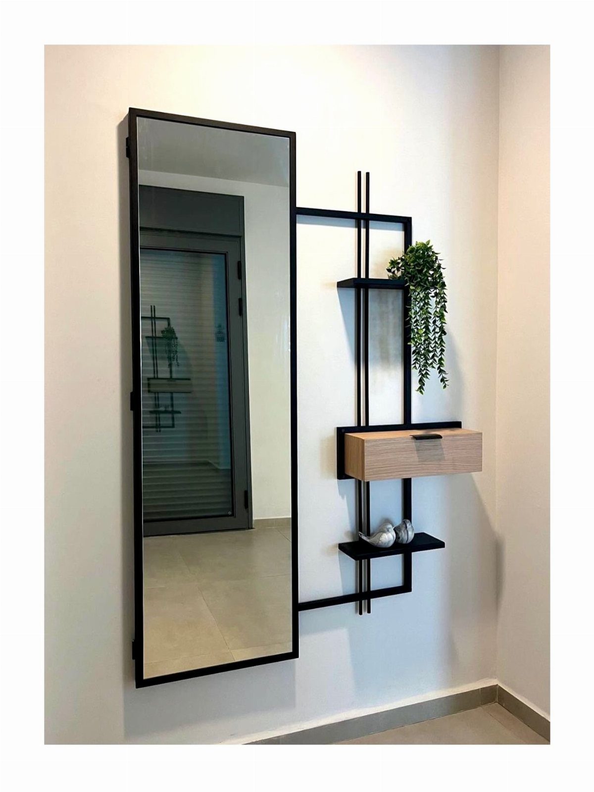 Full length black framed mirror and matching wall shelf unit on white wall