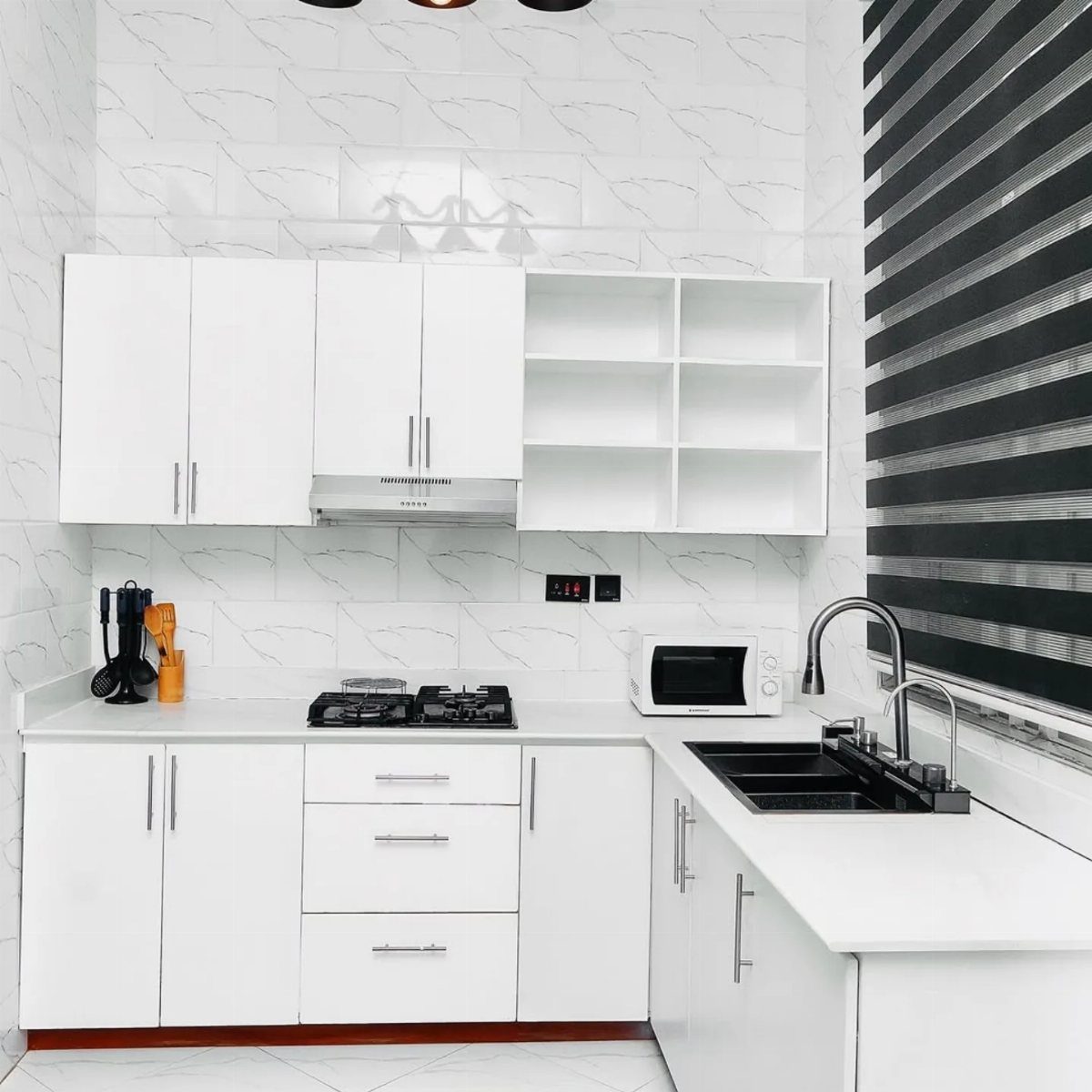 Cabinet Color Trends: 11 Ideas for Your Kitchen in 2026 2 White kitchen cabinets with white countertops and a patterned white tile backsplash.