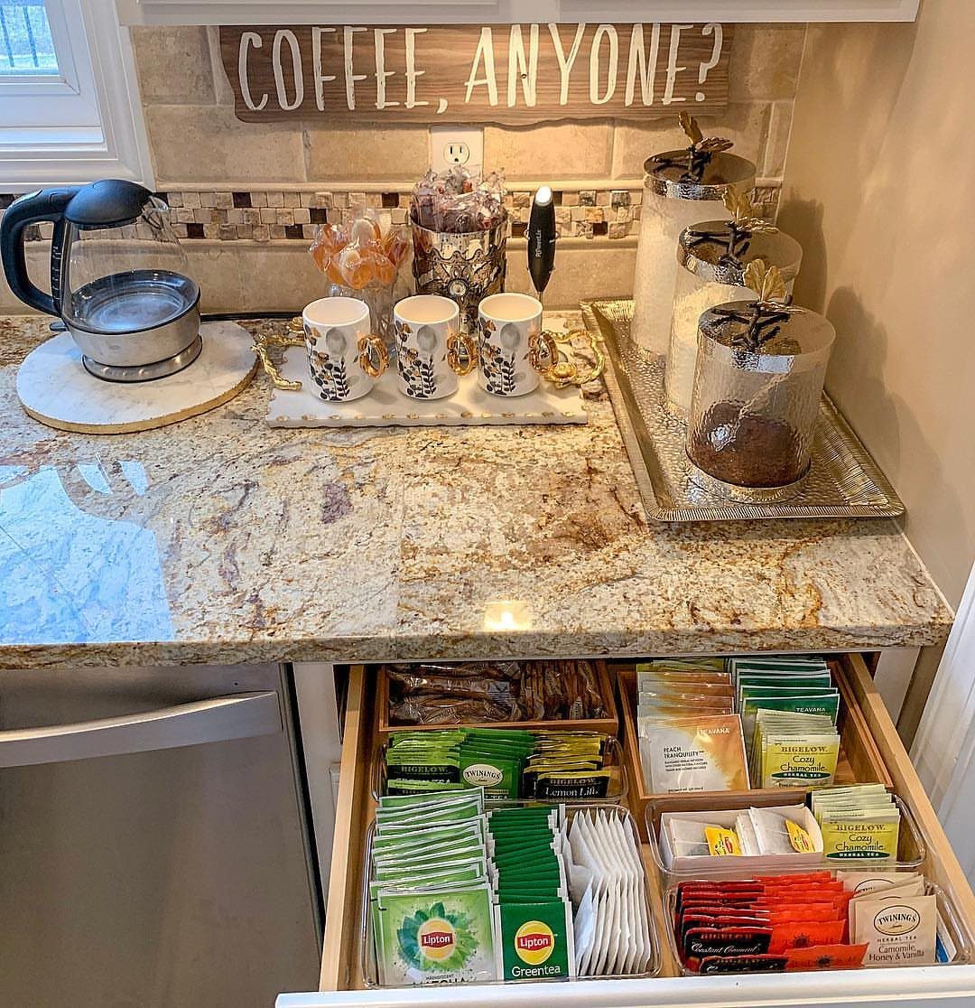 Coffee and tea station with a coffee maker, mugs, and organized pod drawer.