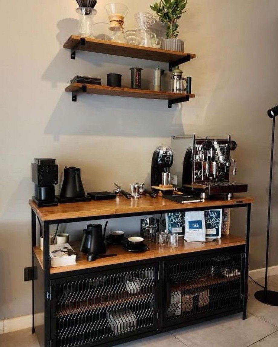 Coffee station with a wooden table, espresso machine, and floating shelves holding pour-over drippers.