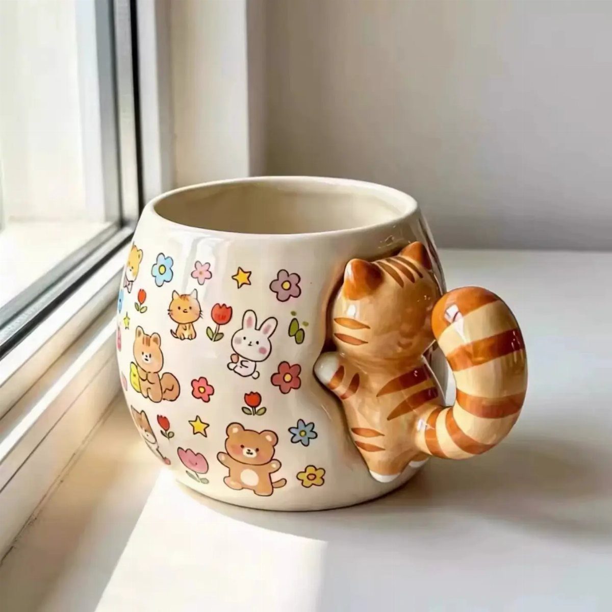 Cream ceramic mug with a sculpted orange cat handle and cartoon animal illustrations.