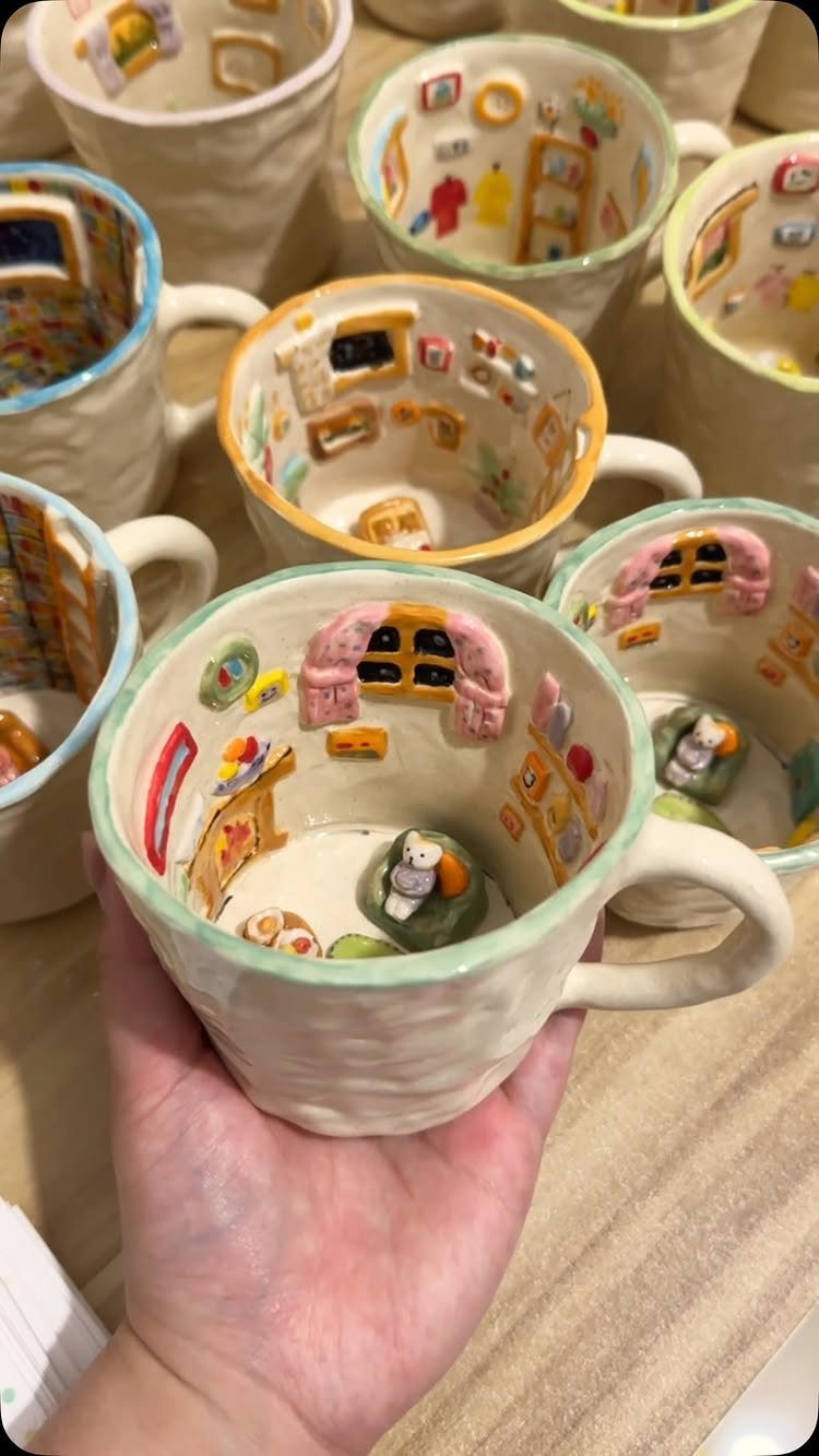 Handmade ceramic mug with a detailed miniature room sculpted inside the interior walls.