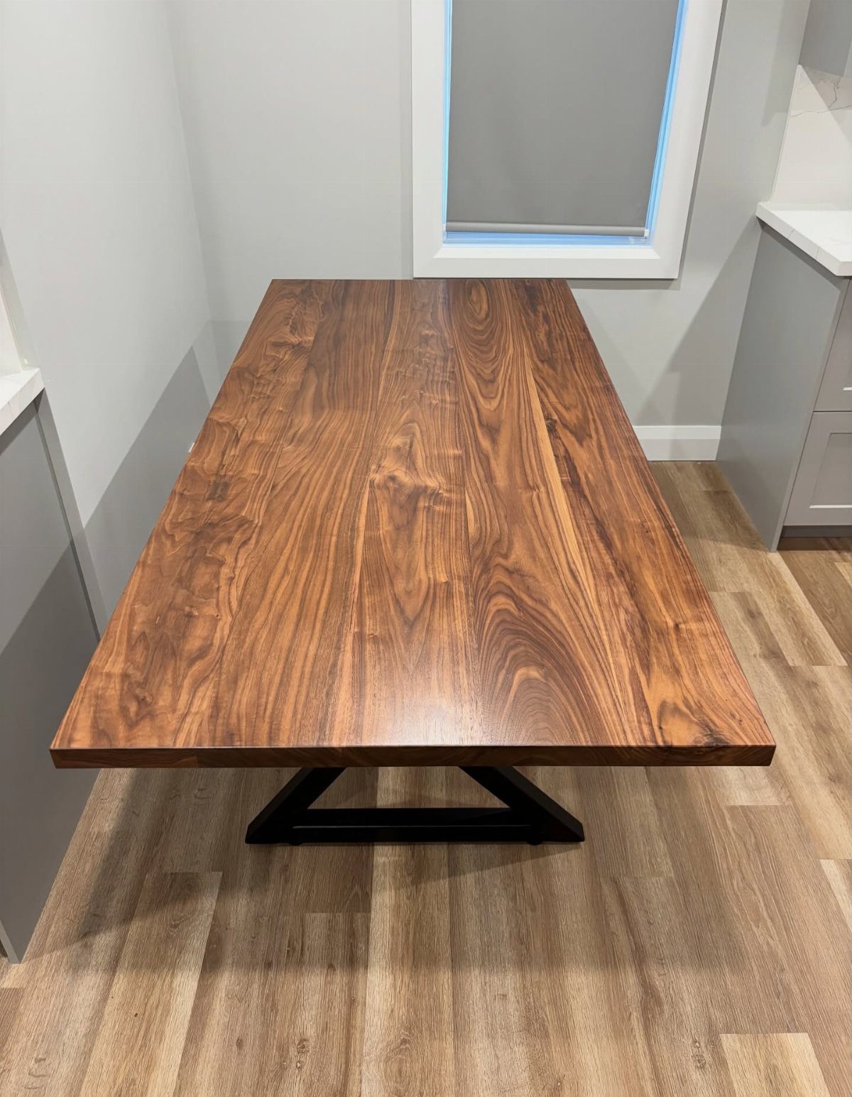 Rectangular dining table with a polished dark wood top and black metal legs.