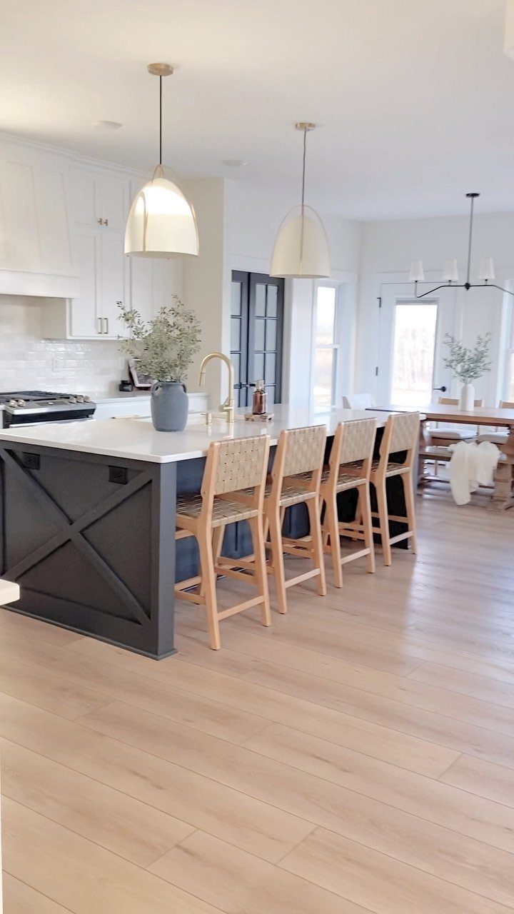 Farmhouse Kitchen Island Ideas: 14 Styles with Photos 5 Dark grey kitchen island with white countertop and light wood bar stools in bright kitchen