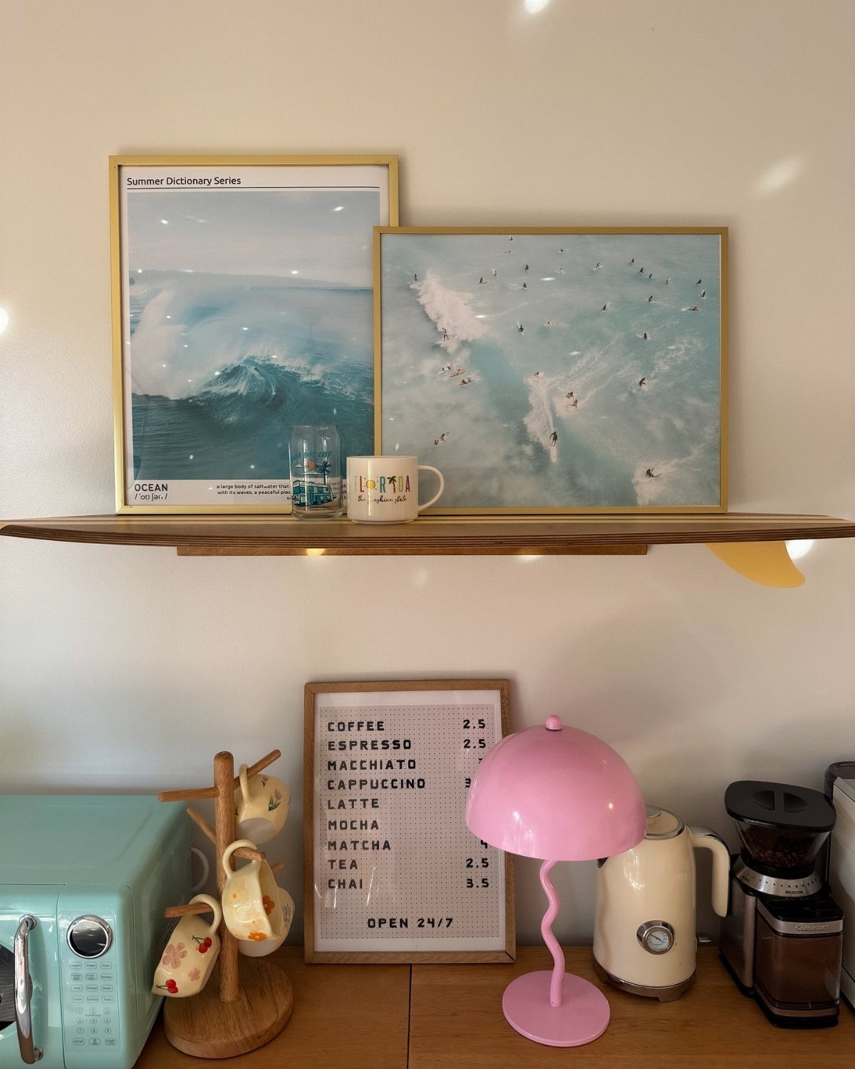 16 Home Coffee Stand Ideas to Fit Any Space 7 Home coffee station with light-colored wooden furniture, pink lamp, and ocean-themed wall art.