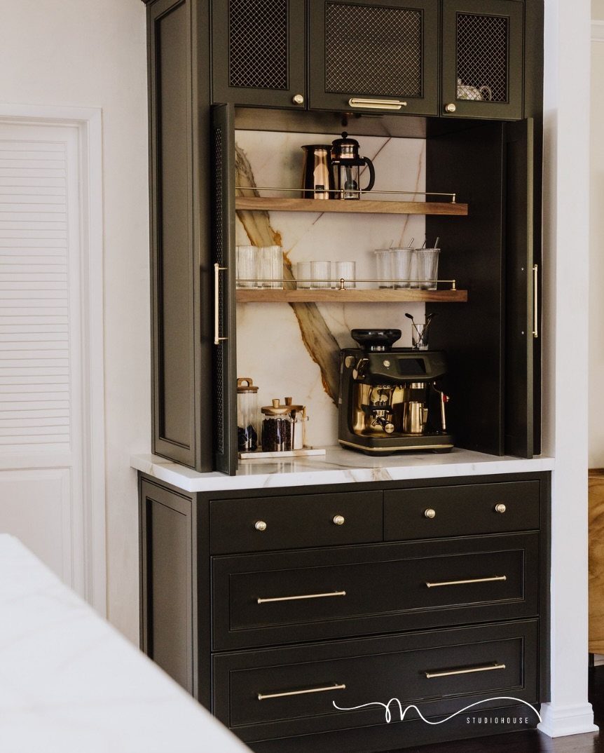 16 Home Coffee Stand Ideas to Fit Any Space 3 Dark green built-in cabinet with open doors revealing a coffee machine and marble backsplash.