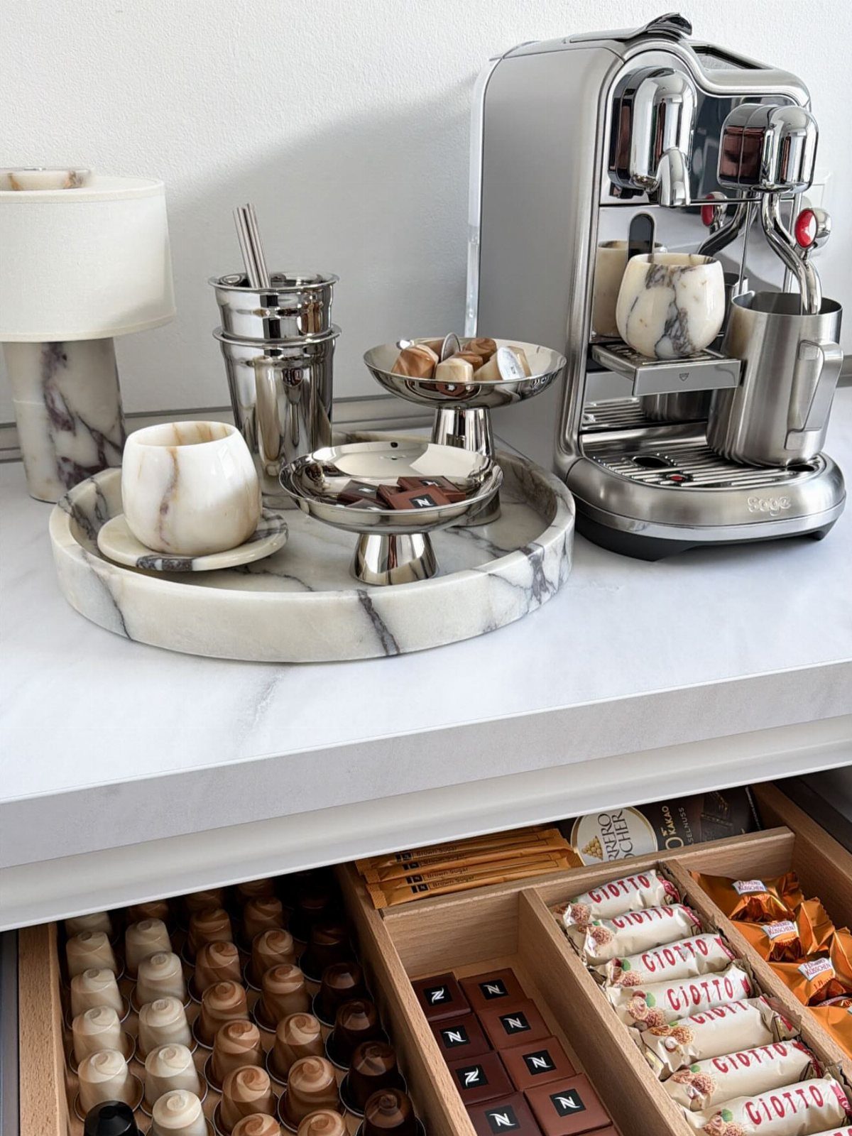 16 Home Coffee Stand Ideas to Fit Any Space 16 Marble coffee station with silver espresso machine and organized drawer of coffee pods.