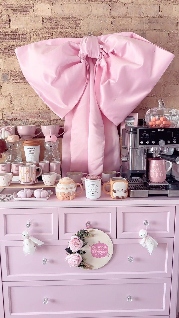 16 Home Coffee Stand Ideas to Fit Any Space 13 Pink dresser coffee station with an espresso machine and large pink bow backdrop.