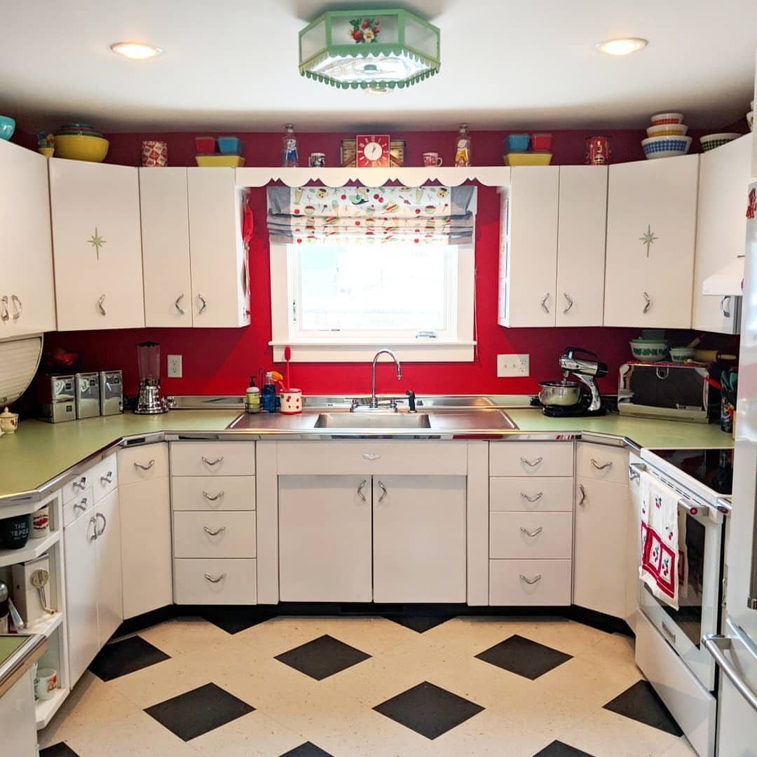 20 Home Kitchen Decor Ideas to Refresh Your Space 6 Retro kitchen with white cabinets, red walls, and colorful accessories on top shelves.