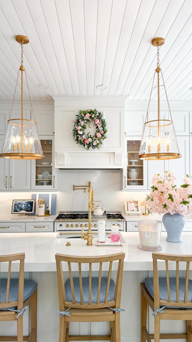 20 Home Kitchen Decor Ideas to Refresh Your Space 4 Two gold and glass pendant lights hanging over a white marble kitchen island.