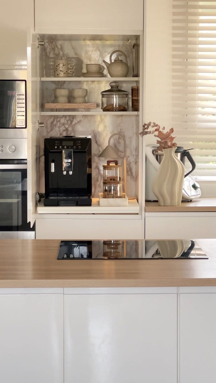 White built-in coffee station with marble backsplash and black espresso machine.