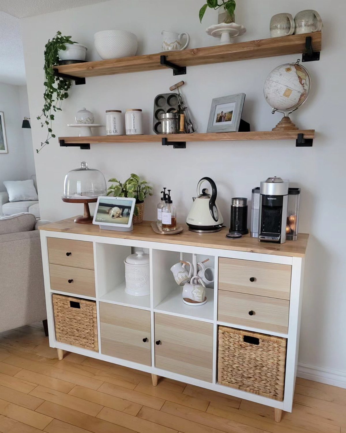 White coffee station cabinet with wooden floating shelves and coffee maker on top