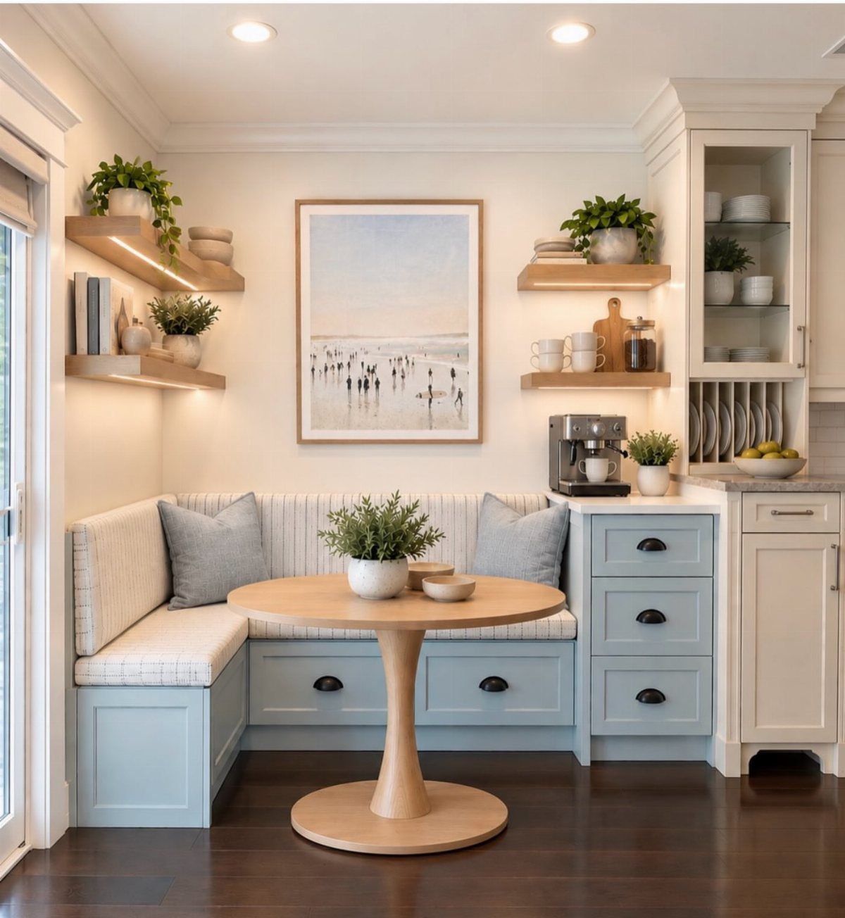 Kitchen breakfast nook with light blue seating, round wooden table, and coffee station.