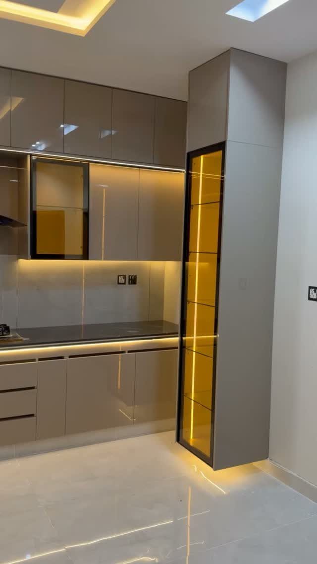 Modern kitchen featuring a tall, narrow slimline cabinet with glowing yellow interior lighting.