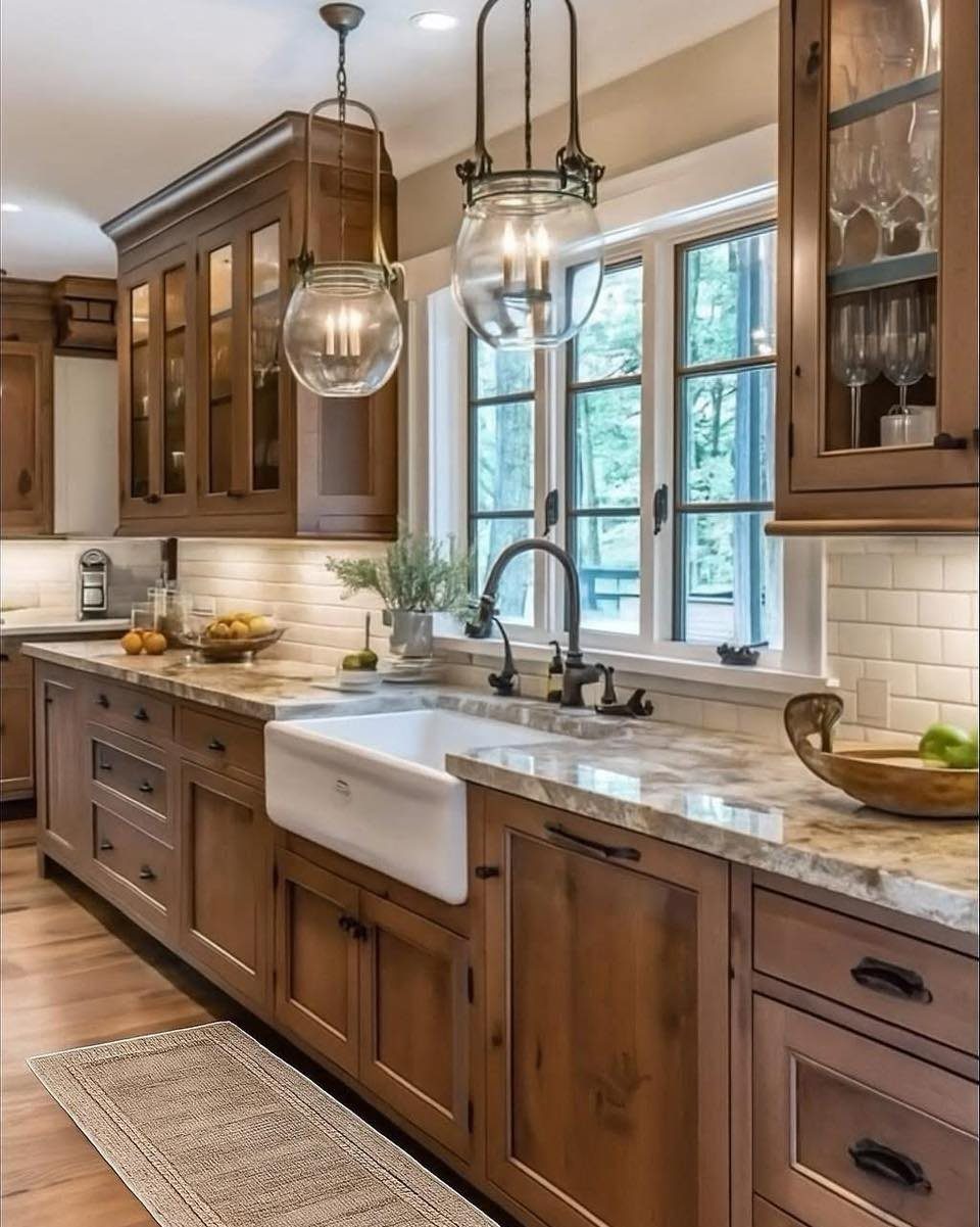 Wooden kitchen cabinets with a white apron-front sink and marble countertops.