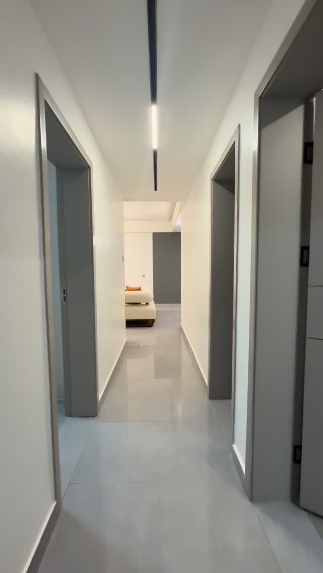 Interior Design Minimalist: 15 Ideas for Clean, Simple Spaces 15 White minimalist hallway with polished grey floors leading to a neutral living area.