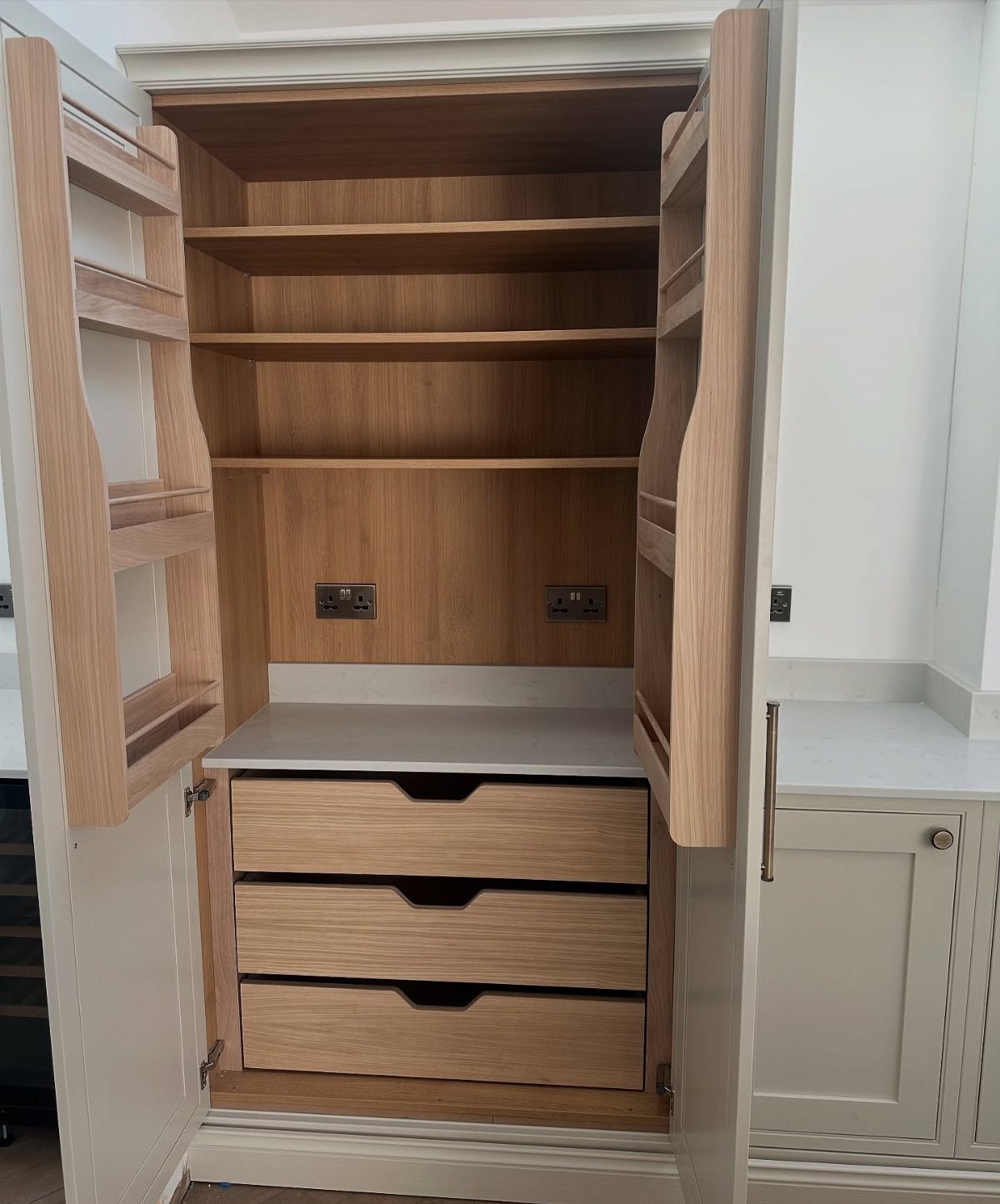 Open wooden kitchen cabinet with storage shelves attached to the inside of the doors.