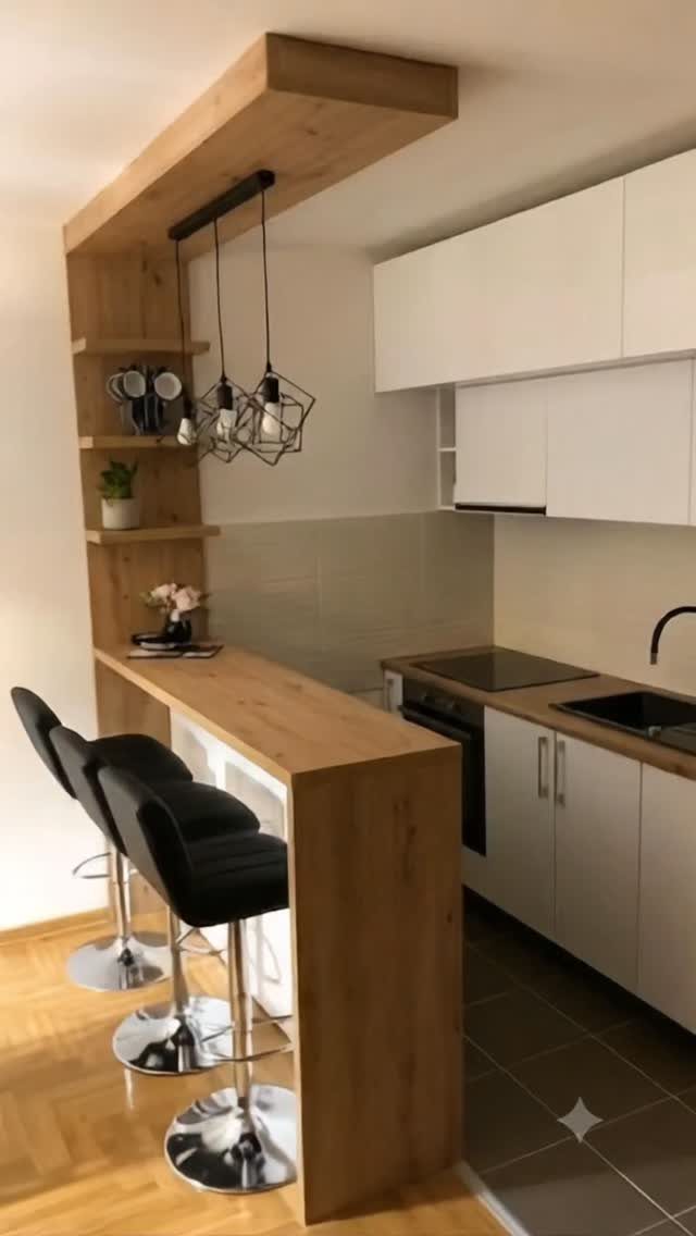 Wooden kitchen half island with black bar stools and white modern cabinetry.