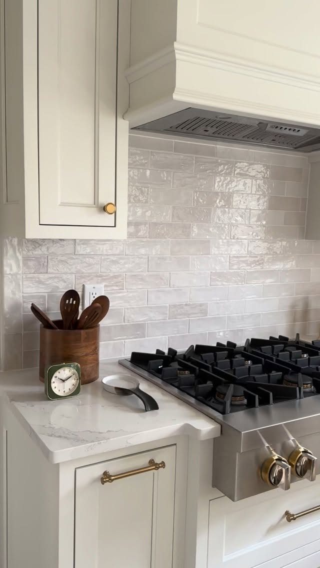 White Cabinets: 13 Kitchen Remodel Ideas 2 Creamy white shaker cabinets with gold hardware and a marble countertop in a kitchen.