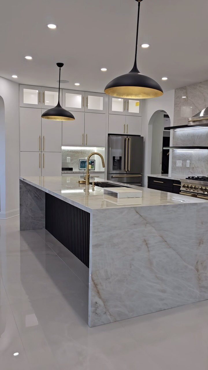 White Cabinets: 13 Kitchen Remodel Ideas 10 Modern kitchen with white cabinets, marble waterfall island, and black pendant lights.