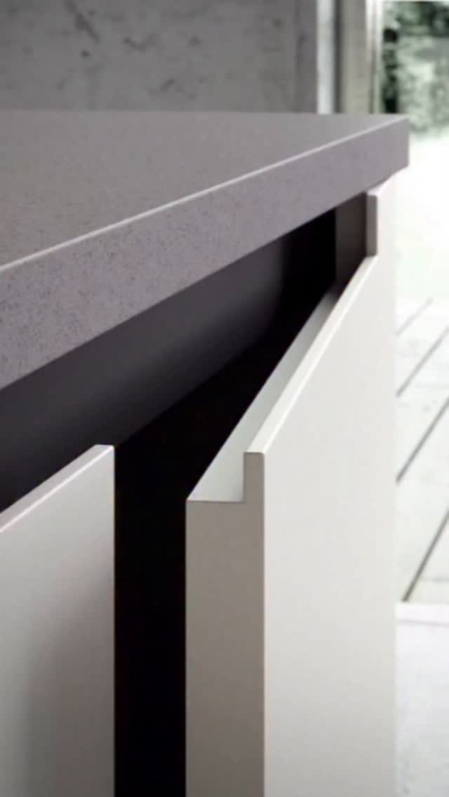 White Cabinets: 13 Kitchen Remodel Ideas 12 White minimalist kitchen cabinets with integrated finger-pulls and a gray matte countertop.