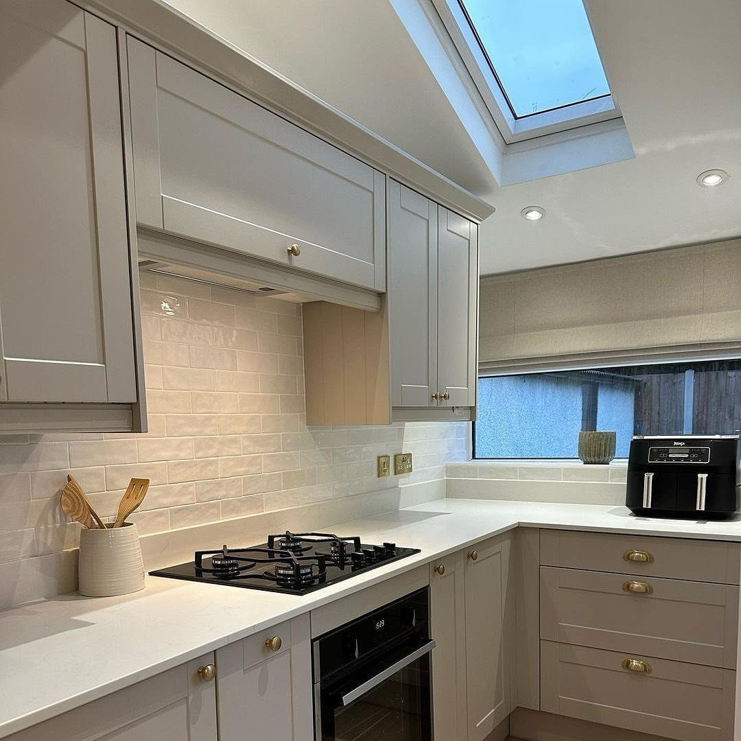 White Cabinets: 13 Kitchen Remodel Ideas 7 White shaker cabinets and a textured handmade tile backsplash in a bright kitchen.