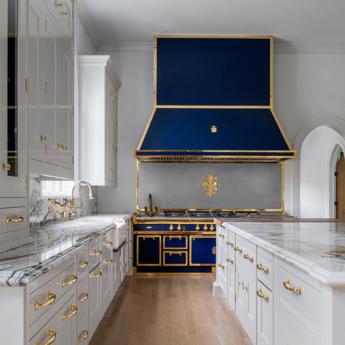 17 Kitchen Stoves Ideas for Every Style and Cooking Need 13 Navy blue range stove and vent hood with gold accents in white kitchen.