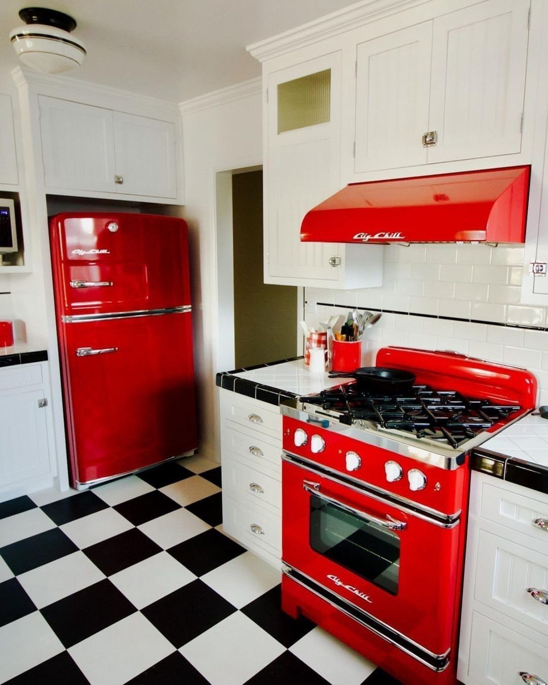 17 Kitchen Stoves Ideas for Every Style and Cooking Need 9 Red vintage-style gas range and matching hood in a checkered floor kitchen.