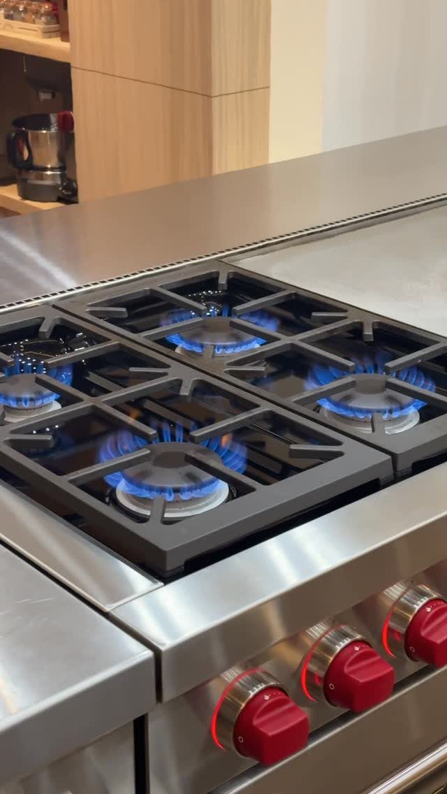 17 Kitchen Stoves Ideas for Every Style and Cooking Need 12 Stainless steel gas range with blue flames and red control knobs in a kitchen