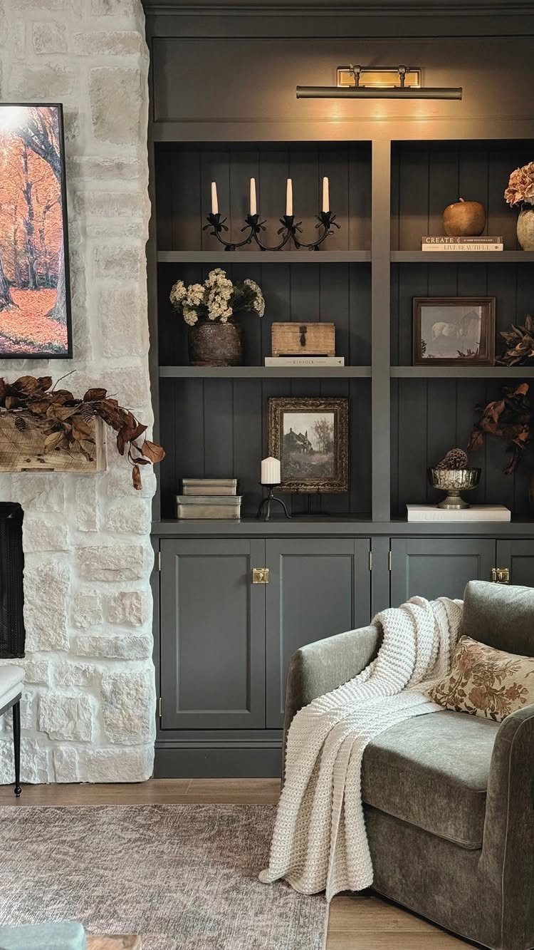 Dark grey built-in shelving unit with cabinets and decorative items next to a stone fireplace.