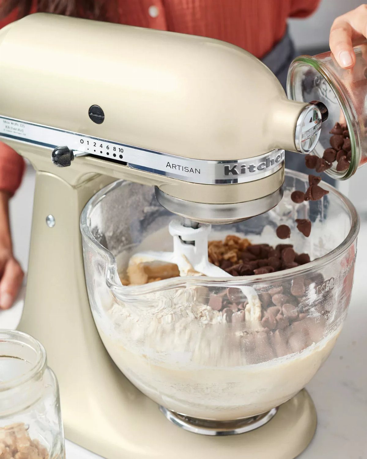 Matte almond cream KitchenAid mixer with glass bowl and chocolate chip batter.