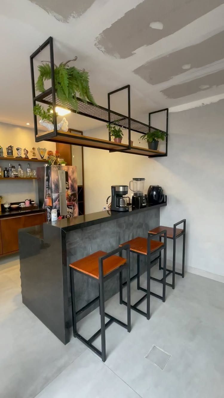 13 Mini Bar House Design Ideas to Fit Your Space and Taste 10 Modern industrial bar with black metal stools and overhead metal shelving with plants.