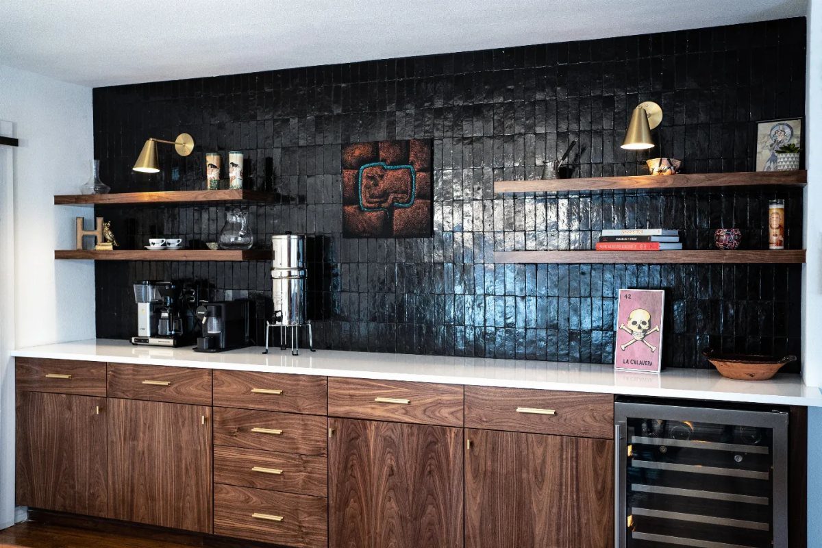 13 Mini Bar House Design Ideas to Fit Your Space and Taste 14 Dark glossy tiled backsplash behind a white countertop with wood cabinets and shelves.