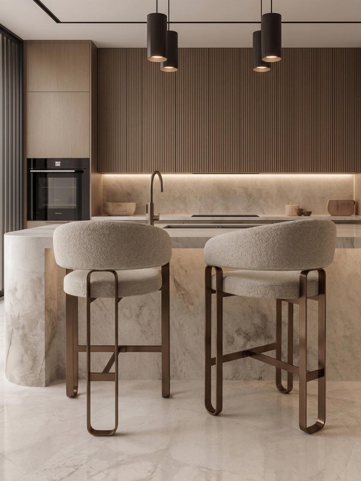 Two grey upholstered bar stools at a white marble kitchen island with wood cabinetry.