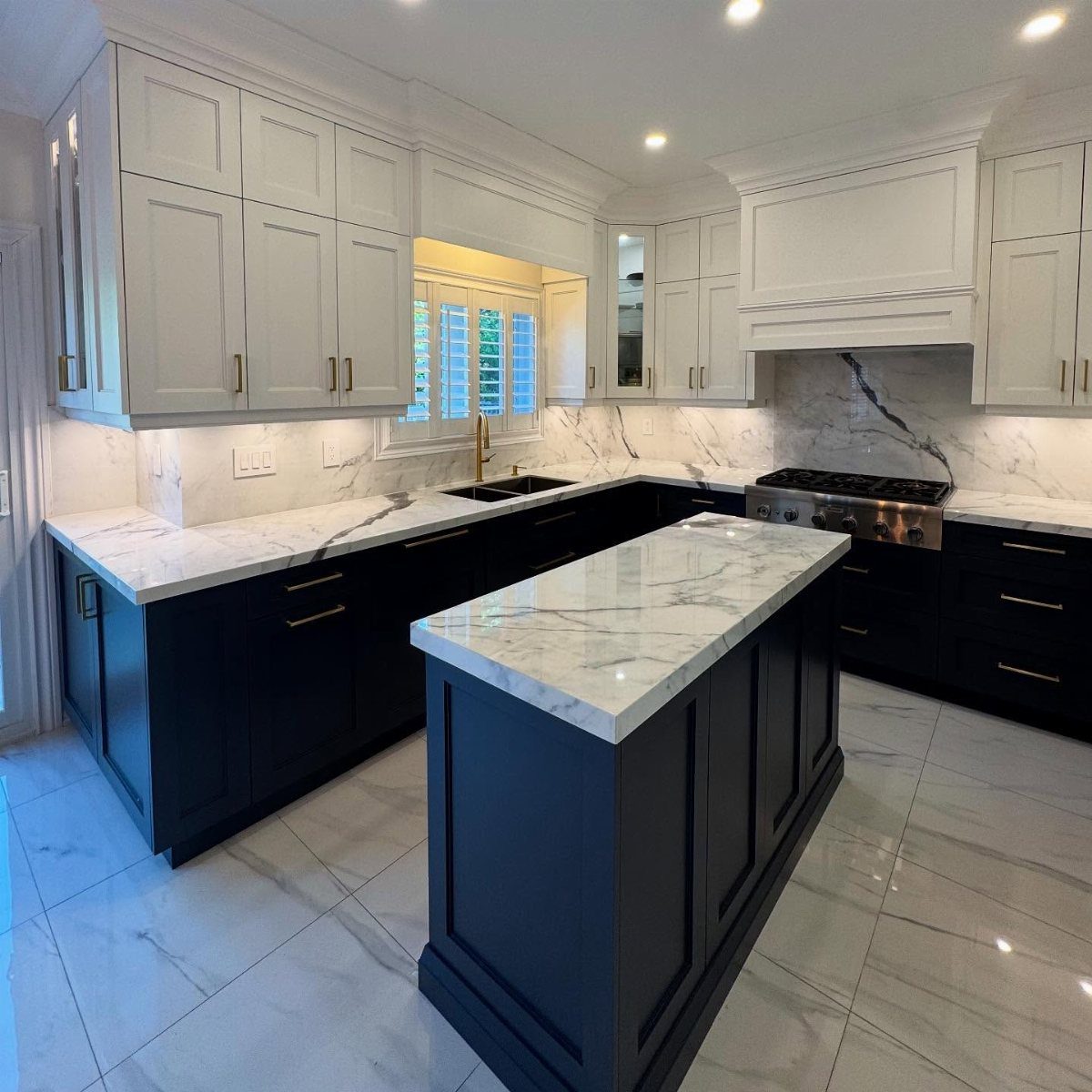 Modern kitchen with white upper cabinets and navy blue lower cabinets and island.