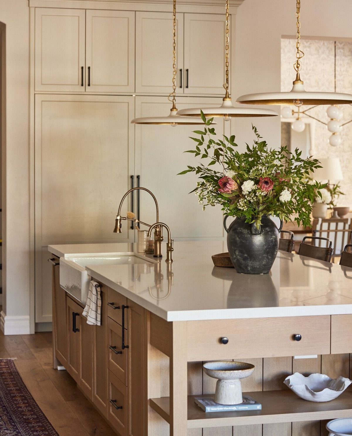 Kitchen island with white countertop and open shelving at the end holding bowls.