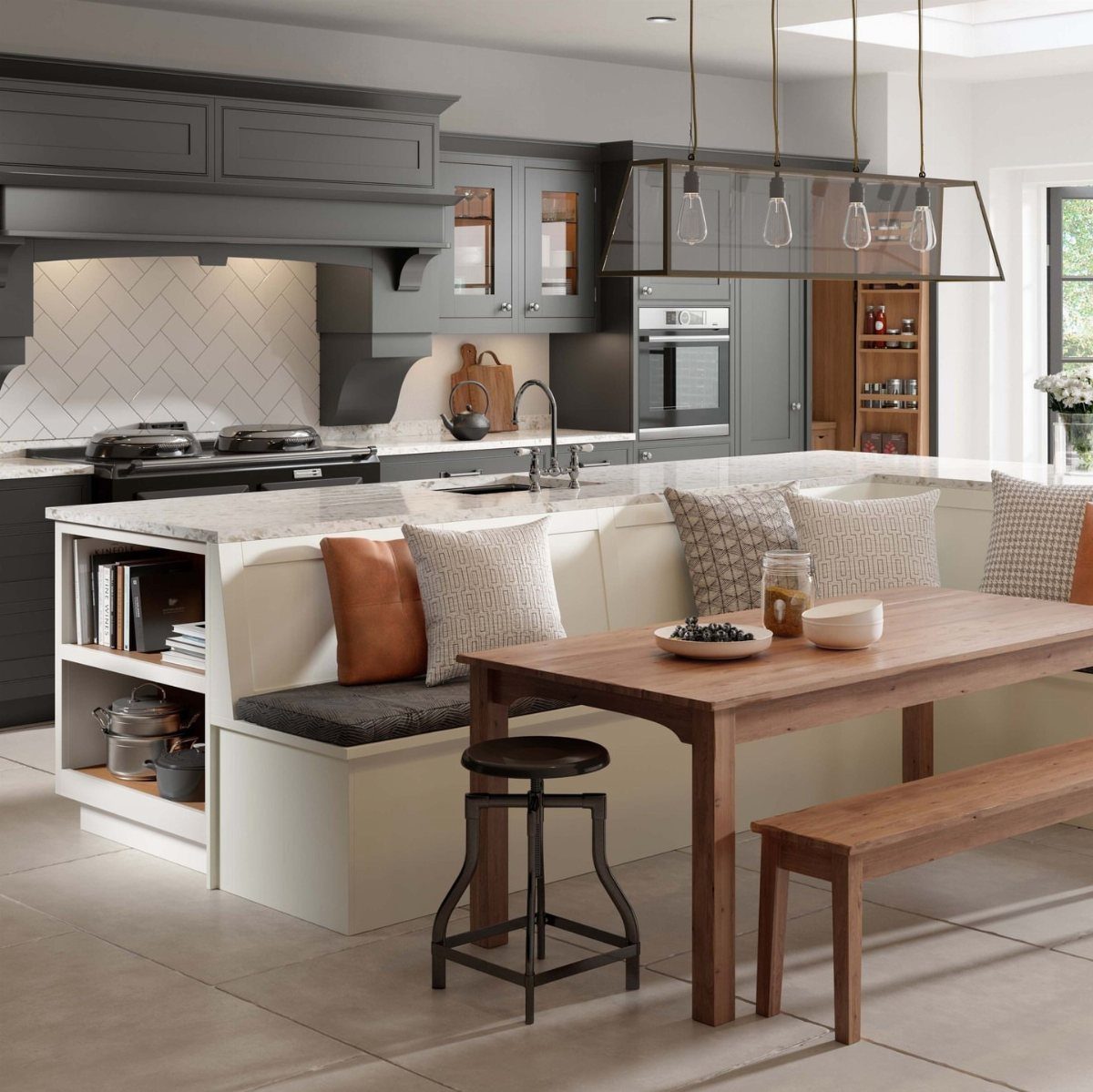 White kitchen island with integrated L-shaped bench seating and a wooden dining table.