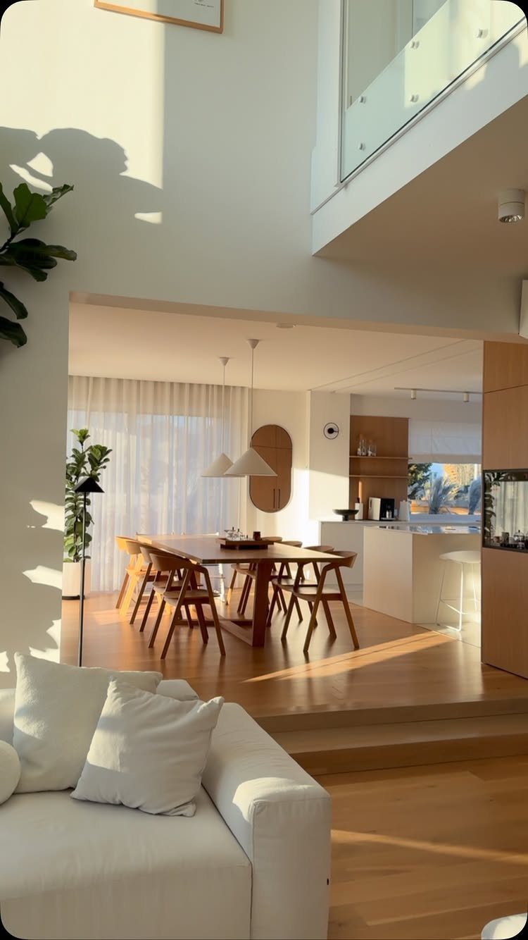 15 Modern Minimalist Home Ideas That Define Clean Living 5 Sunlit open-plan living area with a white sofa and wooden dining set.
