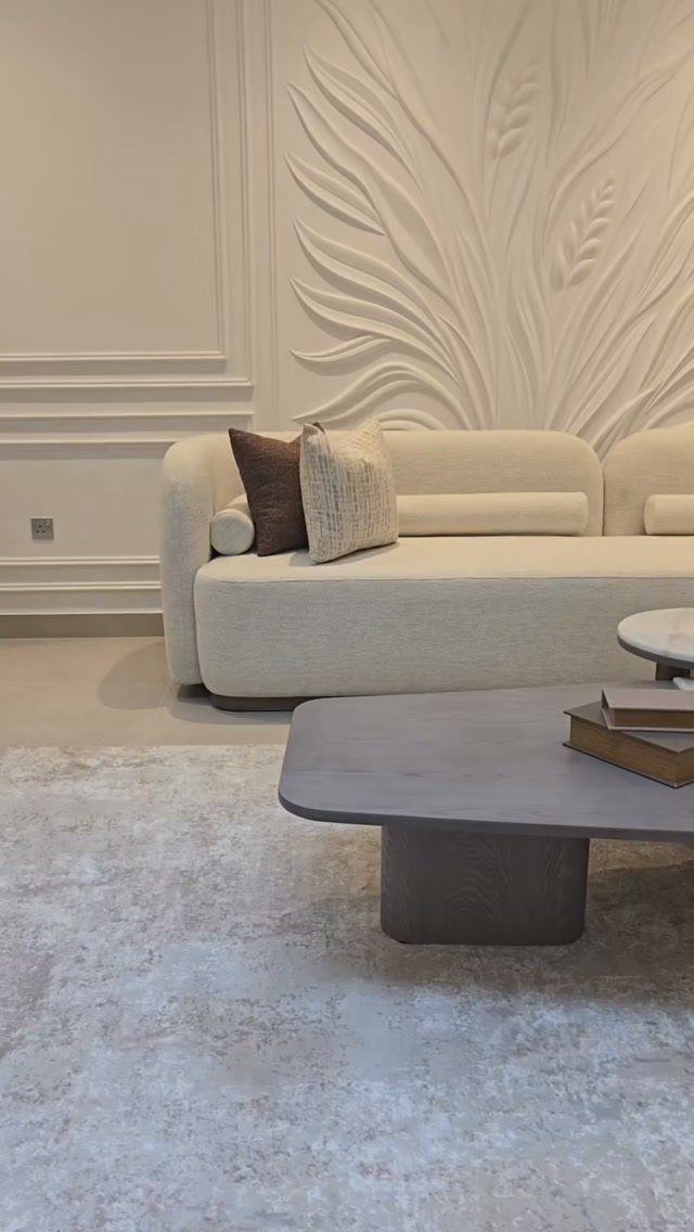 15 Modern Minimalist Home Ideas That Define Clean Living 9 Cream nubby sofa against a white wall with a large 3D leaf sculpture