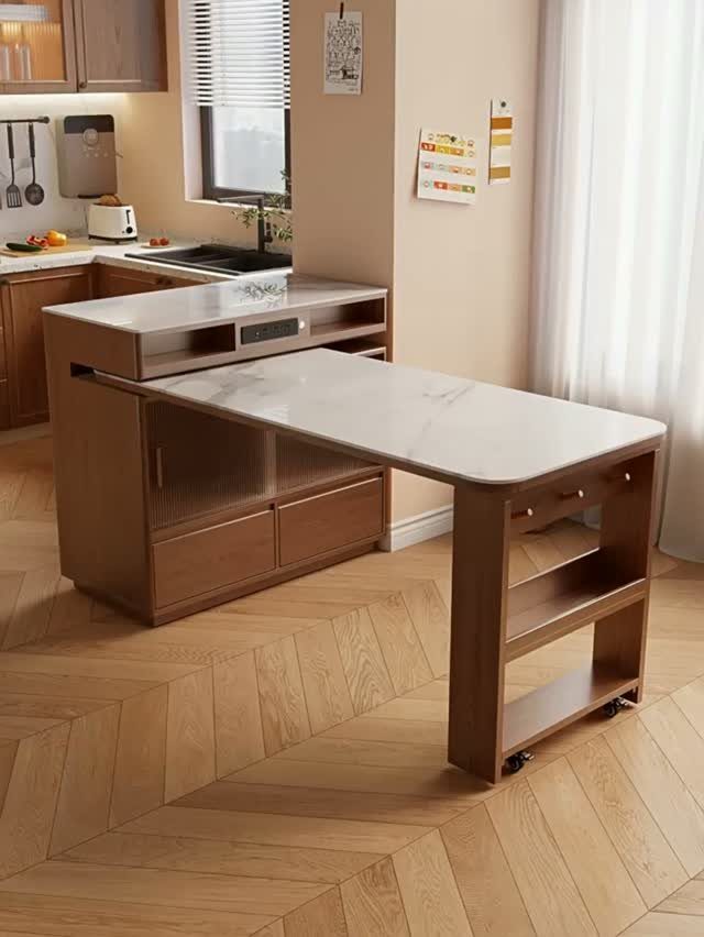 Wooden kitchen island with a white marble top and an extendable surface.